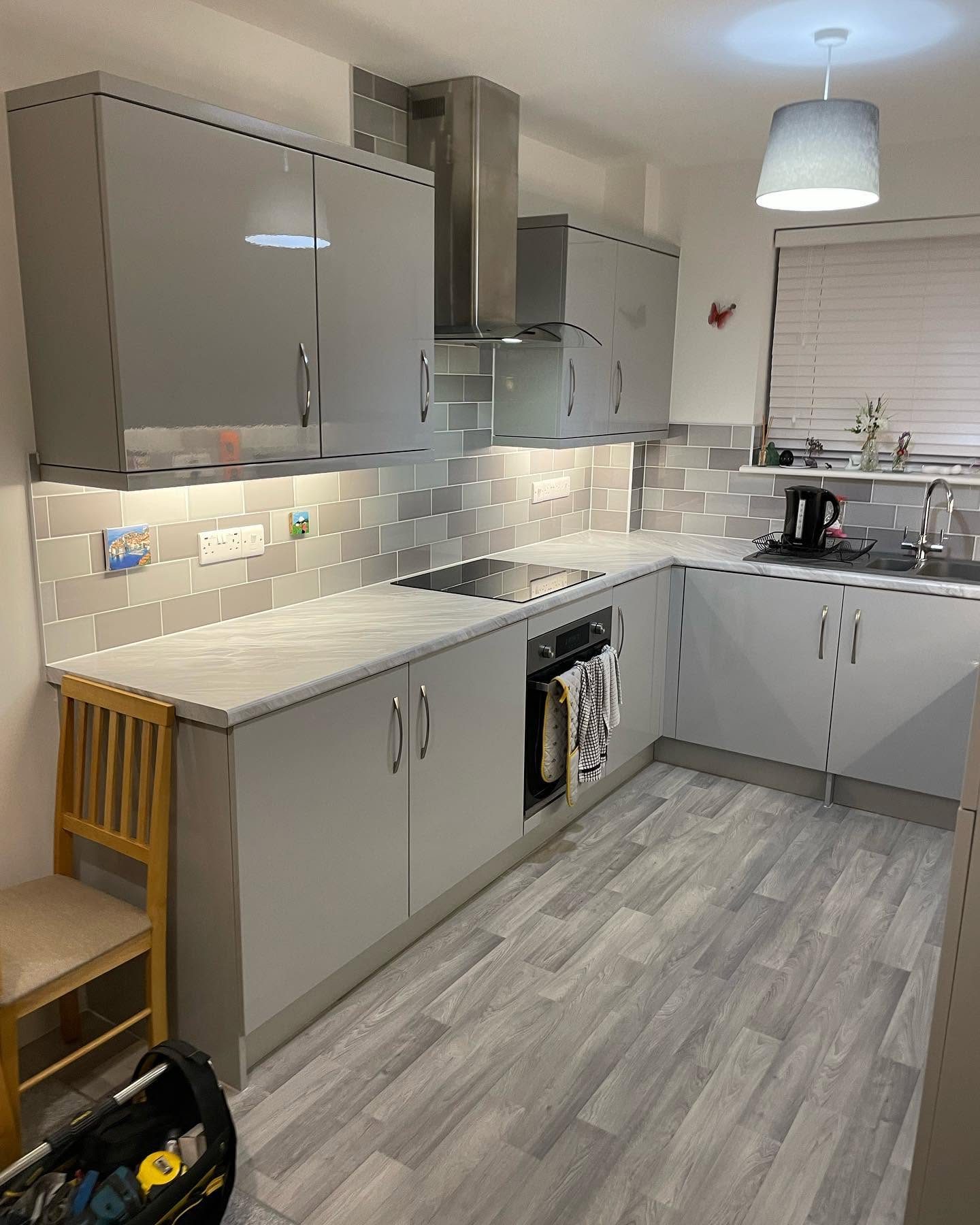 Modern grey kitchen with under-cabinet lighting after electrical installation work