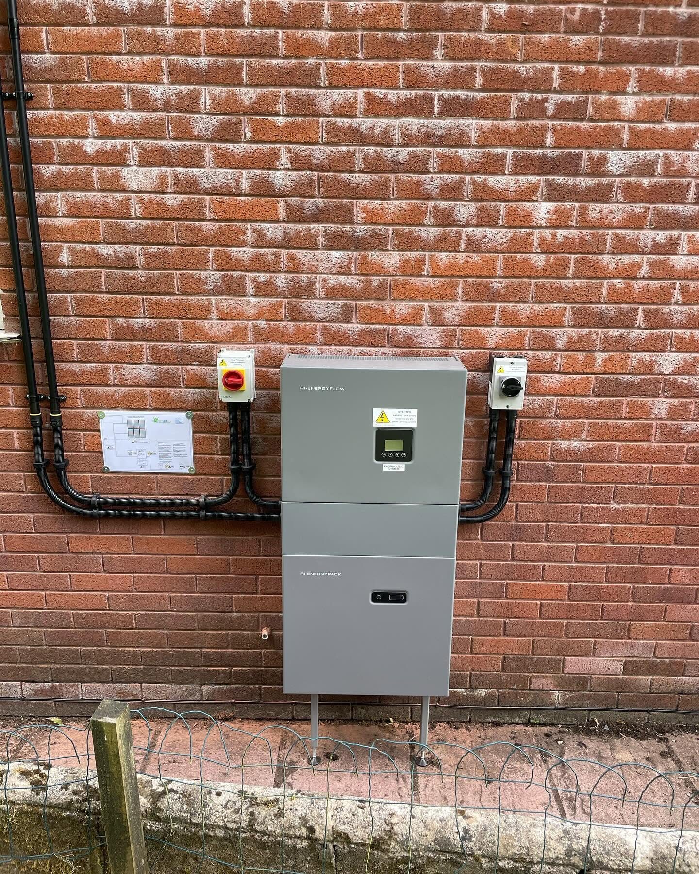 External RI-Energyflow battery storage system installed against a brick wall