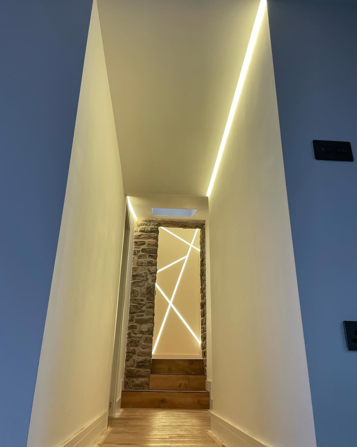 Warm linear LED lighting installed around a hallway stairwell