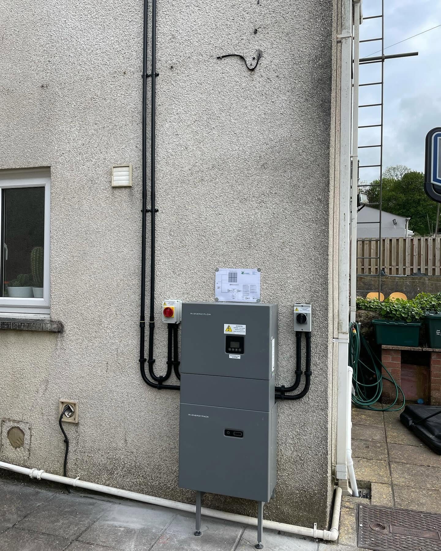 Solar PV inverter installation alongside scaffolding during a domestic solar panel project
