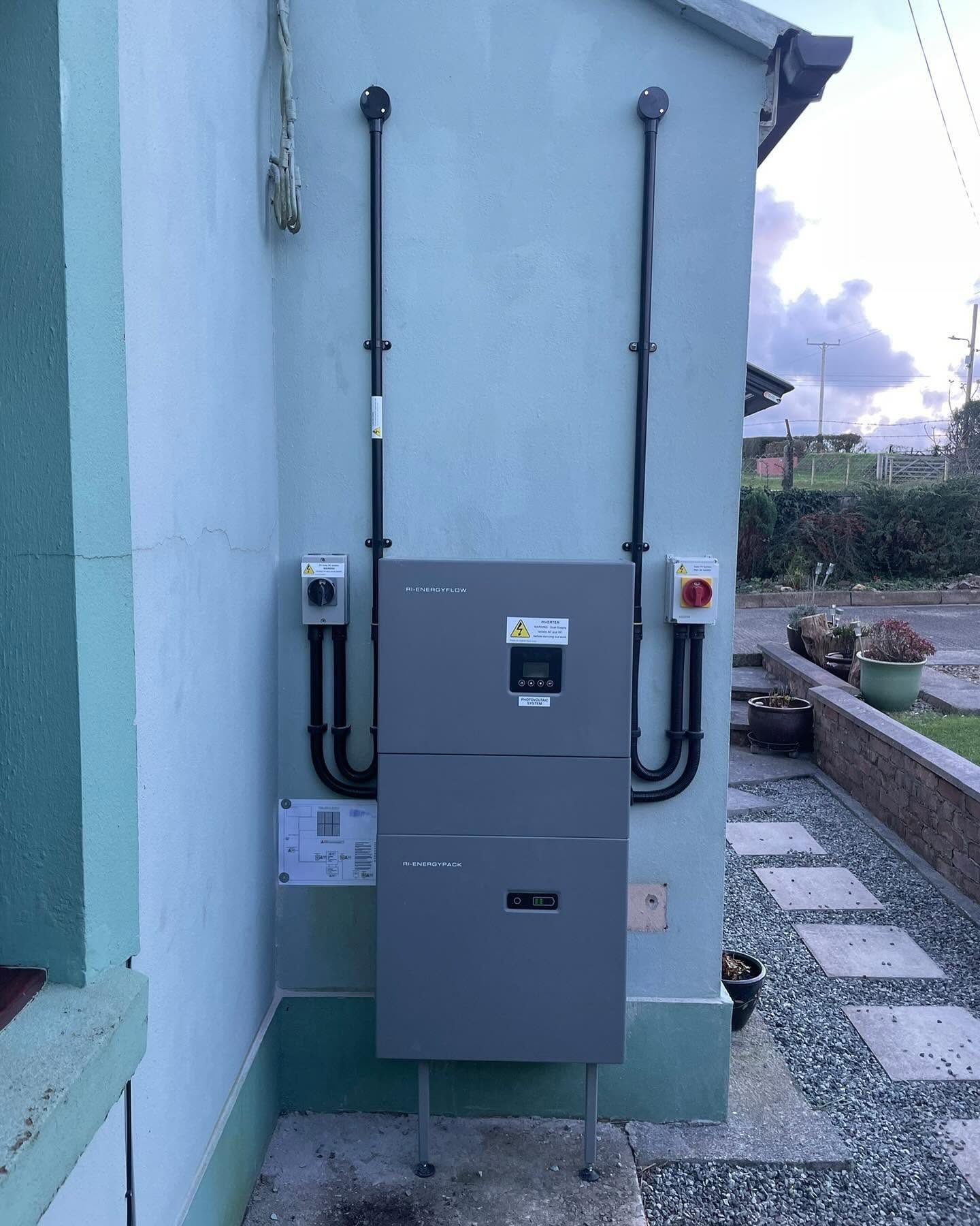 RI-Energyflow inverter and battery storage unit mounted on a rendered external wall
