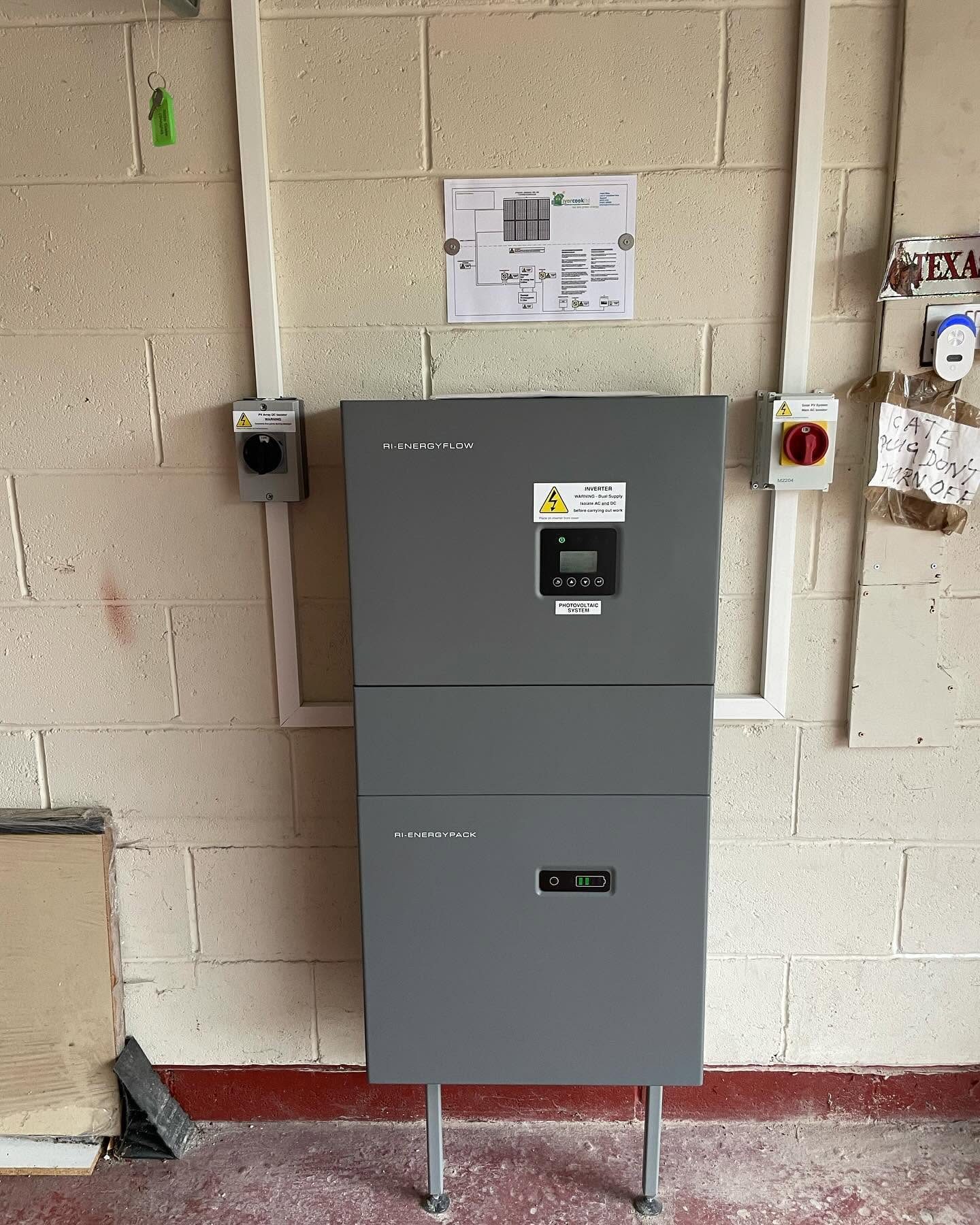 Wall-mounted battery storage and inverter installation on a block-built garage wall