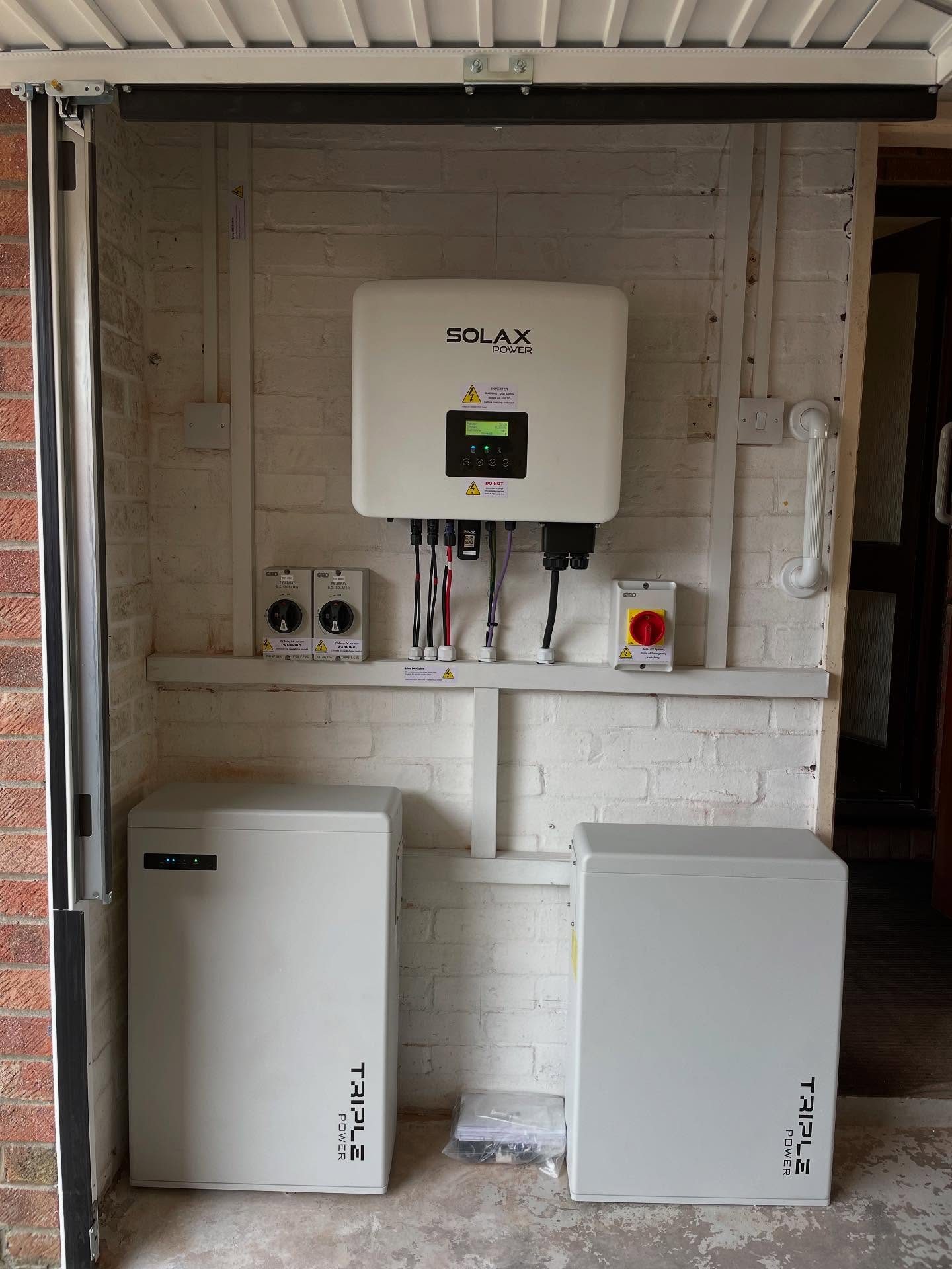 SolaX hybrid inverter with two Triple Power home battery units installed in a garage